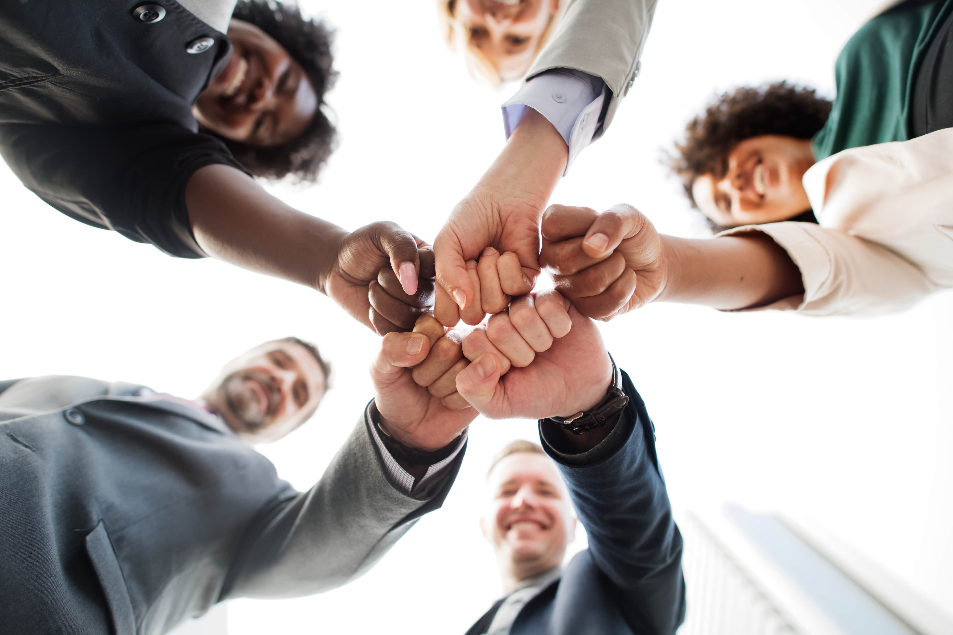 Equipe unindo as mãos em gesto de colaboração